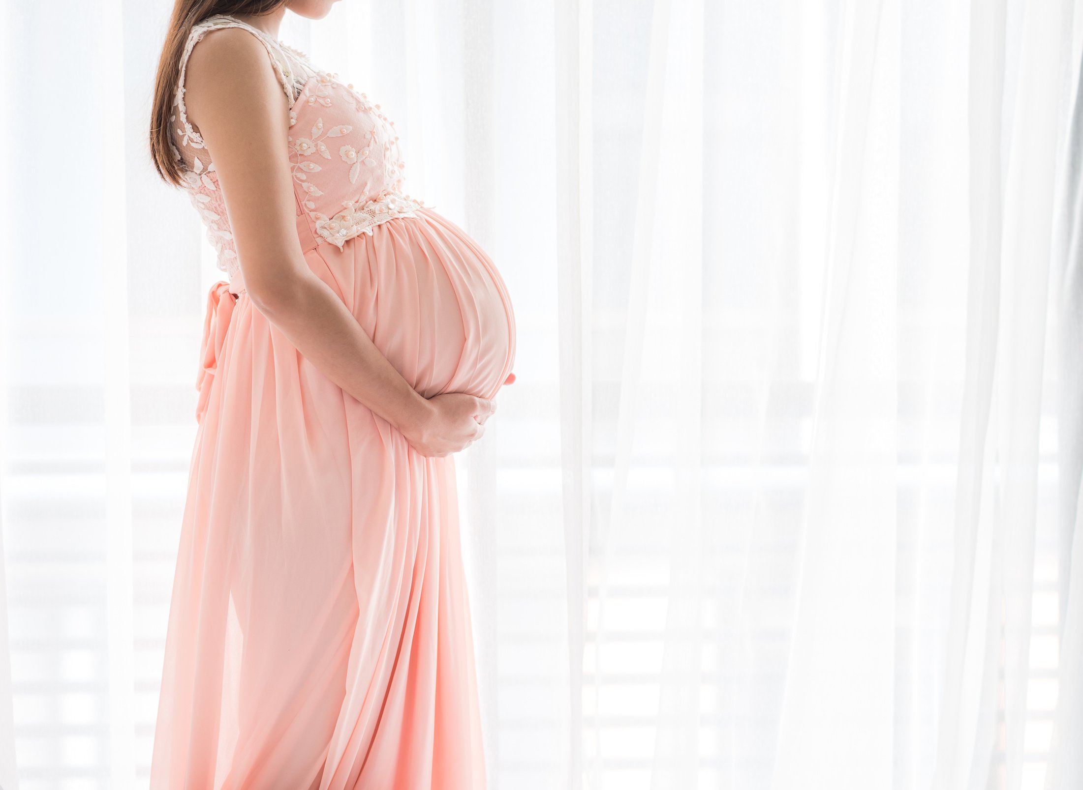 Pregnant Woman by the Curtain